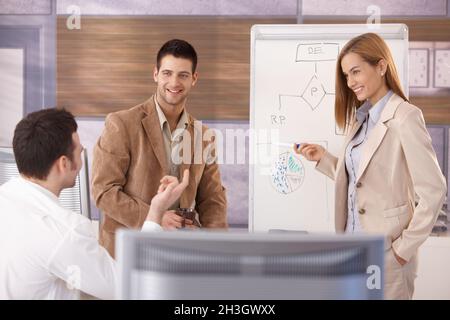 Fröhlicher Geschäftsteam, der lächelnd zusammenarbeitet Stockfoto