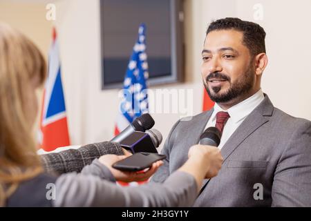 Ein selbstbewusster arabischer bärtiger Politiker kommentierte seinen Bericht, während er nach der Konferenz mit der Presse sprach Stockfoto