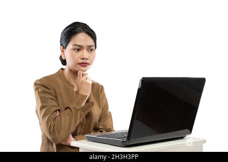 Verwirrt Frau in Beamtenuniform Blick auf Laptop Stockfoto