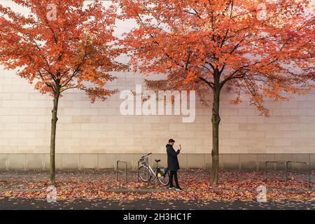 Berlin, Deutschland. Oktober 2021. Ein Mann fotografiert am 28. Oktober 2021 die Herbstlandschaft in Berlin, der Hauptstadt Deutschlands. Kredit: Shan Yuqi/Xinhua/Alamy Live Nachrichten Stockfoto