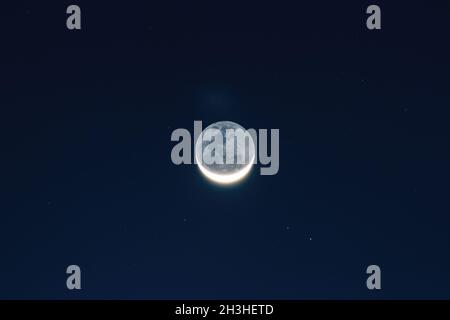 Mond am Stadthimmel Stockfoto