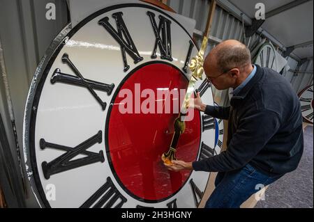 Regensburg, Deutschland. Oktober 2021. Sören Draack, Geschäftsführer des Turmuhrherstellers Rauscher, hält eine Hand vor dem Zifferblatt einer Turmuhr. Am Sonntag (31.10.2021) wird die Uhr von drei auf zwei Uhr Winterzeit zurückgestellt. Quelle: Armin Weigel/dpa/Alamy Live News Stockfoto