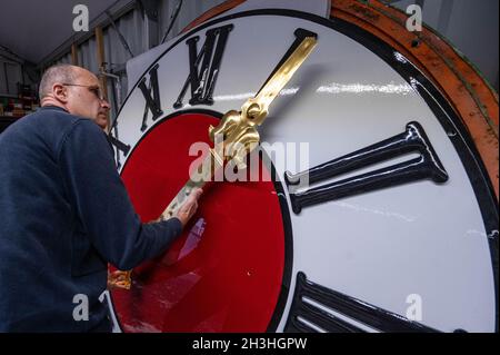 Regensburg, Deutschland. Oktober 2021. Sören Draack, Geschäftsführer des Turmuhrherstellers Rauscher, hält eine Hand vor dem Zifferblatt einer Turmuhr. Am Sonntag (31.10.2021) wird die Uhr von drei auf zwei Uhr Winterzeit zurückgestellt. Quelle: Armin Weigel/dpa/Alamy Live News Stockfoto