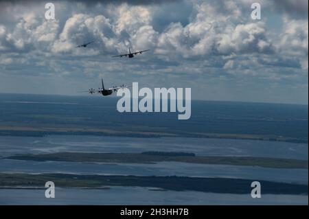 Drei dem 317. Luftlift-Flügel zugewiesene Super Hercules-Flugzeuge C-130J fliegen über den Ozean in der Nähe von Key West, Florida, 19. Oktober 2021. Die C-130 gehören seit über 50 Jahren zur Flotte der US Air Force. (USA Luftwaffe Foto von Senior Airman Reilly McGuire) Stockfoto