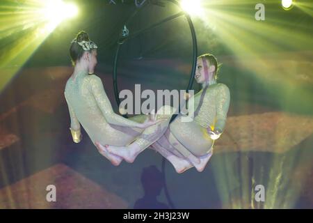 Zirkus Schauspielerin acrobat Leistung. Zwei Mädchen führen akrobatische Elemente in der Luft. Stockfoto