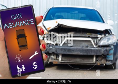 Frau Hand hält Smartphone, um Kfz-Versicherung Anwendung online nach seinem kaputten Auto zu verwenden. Versicherungskonzept. Stockfoto