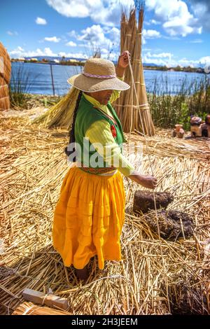 TITICACASEE, PERU - DEC 29: Indische Frau, die ihre Waren feilbieten, auf ein Rohr Insel Uros im Titicaca-See, am 29. Dezember 2013 in Titicac Stockfoto