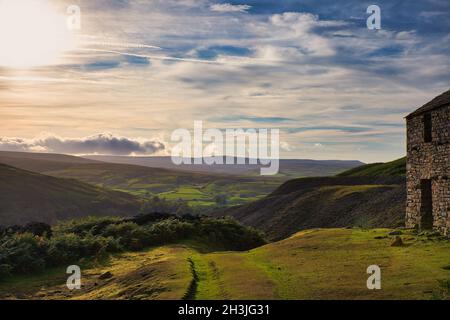 Verlassene ehemalige Beldi Hill Bleibergwerk auf einem Hügel über Crackpot Hall bei Sonnenuntergang, Swaledale, North Yorkshire, England Stockfoto