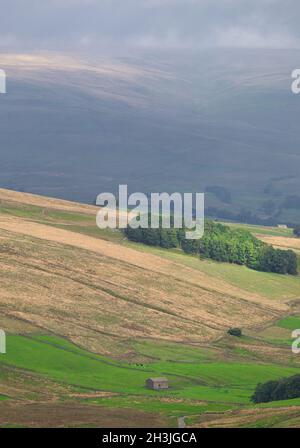 Dramatisches atmosphärisches Licht auf zerklüfteten Bergen mit Steinscheune im Vordergrund, Yorkshire Dales National Park, North Yorkshire, England Stockfoto