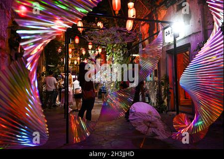 Kuala Lumpur, Malaysia. Oktober 2021. Besucher der Kunstinstallationen unter dem Motto „Illuminating Shadows“ während einer Medienvorschau im Kwai Chai Hong in Kuala Lumpur, Malaysia, am 28. Oktober 2021. Inspiriert von den Herausforderungen, denen Menschen im Leben gegenüberstehen, hoffen die Schöpfer, positive Schwingungen zu verbreiten und die Art und Weise zu verändern, wie Dinge inmitten der aktuellen COVID-19-Pandemie wahrgenommen werden, indem sie eine andere Perspektive auf Licht und Schatten bieten. Quelle: Zhu Wei/Xinhua/Alamy Live News Stockfoto