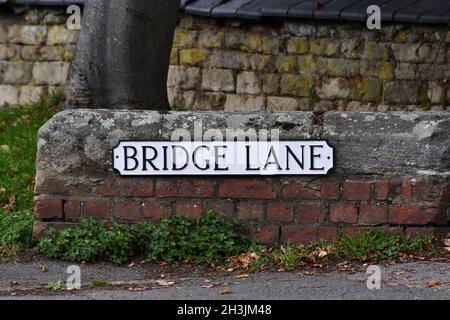 Ein Straßenschild an einer kleinen englischen Ziegelmauer mit Betonsteinen, genannt Brick Lane Stockfoto