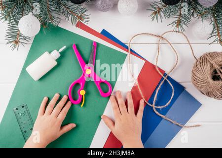 Schritt-für-Schritt-Grußkarte 3D-Weihnachtsbaum-Tutorial. Schritt 1: Sie benötigen A4-Blätter aus Karton und grünem Papier, Schere, Lineal, Kleber, ro Stockfoto