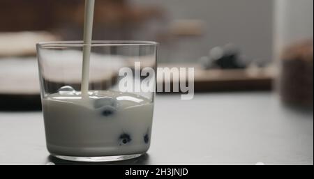 Granola mit Blaubeeren im Glas mit Kopierraum, breites Foto Stockfoto