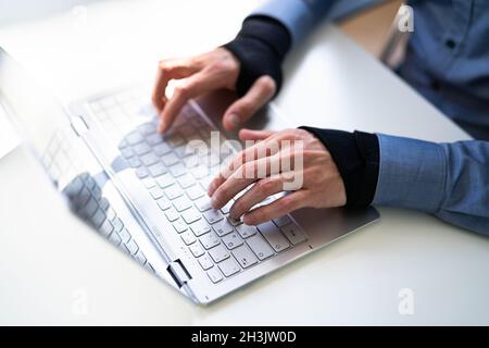 Pain Relief Bandage Und Handgelenkschlaufe. Tippen Auf Der Tastatur Stockfoto