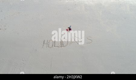 Urlaub in den Sand geschrieben am Strand Stockfoto