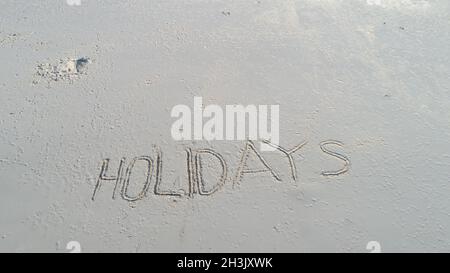 Urlaub in den Sand geschrieben am Strand Stockfoto