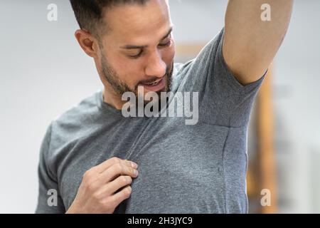 Sportler, Der Antitranspirant Deodorant Gegen Hyperhidrose-Schwitzen Verwendet Stockfoto