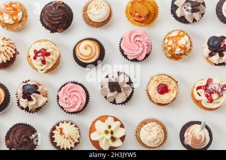 Viele bunte Cupcakes von oben mit Toppings und Dekorationen für einen Geburtstag Stockfoto