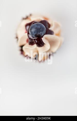Cupcake von oben mit Heidelbeere als Dekoration und Heidelbeersoße Stockfoto