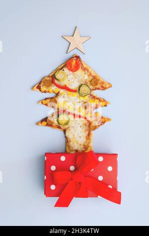 Leckere vegetarische Weihnachtsbaum-Pizza mit Tomaten, Gemüse und Käse auf weißem Hintergrund. Kreatives, witziges Food-Konzept für Kinder. Draufsicht Stockfoto