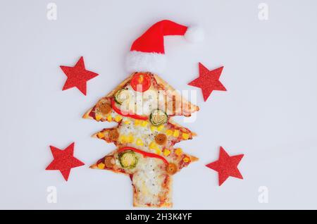 Leckere vegetarische Weihnachtsbaum-Pizza mit Tomaten, Gemüse und Käse auf weißem Hintergrund. Kreatives, witziges Food-Konzept für Kinder. Draufsicht Stockfoto