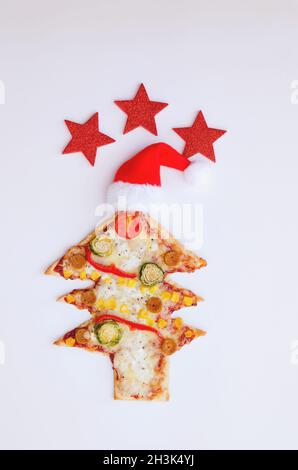 Leckere vegetarische Weihnachtsbaum-Pizza mit Tomaten, Gemüse und Käse auf weißem Hintergrund. Kreatives, witziges Food-Konzept für Kinder. Draufsicht Stockfoto