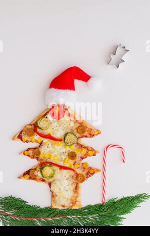 Leckere vegetarische Weihnachtsbaum-Pizza mit Tomaten, Gemüse und Käse auf weißem Hintergrund. Kreatives, witziges Food-Konzept für Kinder. Draufsicht Stockfoto