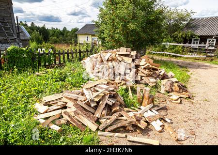 Gehackt und gestapelt trockenes Brennholz auf dem Land. Stock Haufen Holz, abgehackt Bäume im Dorf Stockfoto