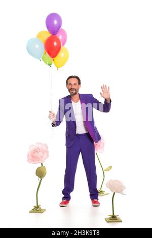 Netter Mann mit Ballons und Blumen Stockfoto