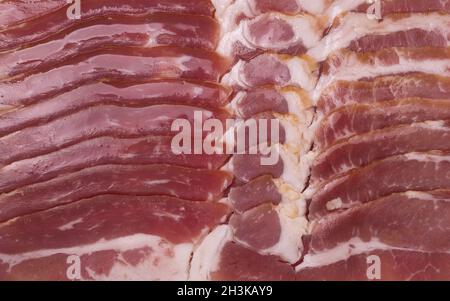 Frischen in Scheiben geschnittenen Speck als Hintergrund. Nahaufnahme, Ansicht von oben. Stockfoto