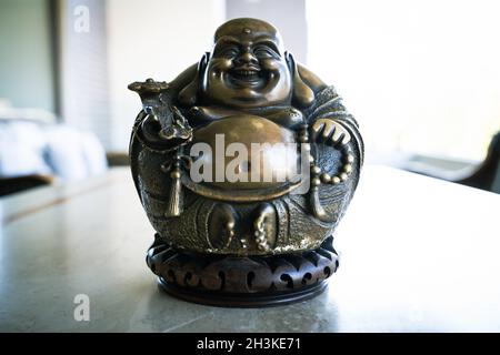 Lachender Buddha der Fülle, Freude und Glück goldene Farbe Statue. Viel Glück Symbol Figur Dekoration Stockfoto