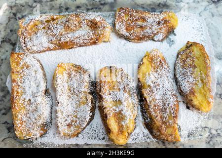 Traditionelle französische Toasts auf Puderzucker. Draufsicht auf Brotscheiben, süße Frühstückskonzepte Stockfoto