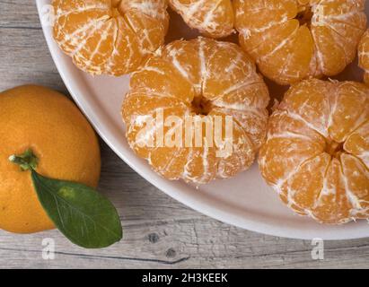 Frische reife Geschälte Mandarine in einer Schüssel auf einem hölzernen Hintergrund. Nähe zu sehen. Stockfoto