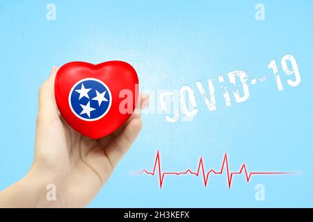 Ein Mädchen hält ein Spielzeug in Form eines Herzens mit der Flagge des Staates Tennessee, einem Konzept der Gesundheitsversorgung während der Covid-19-Coronavirus-Pandemie Stockfoto