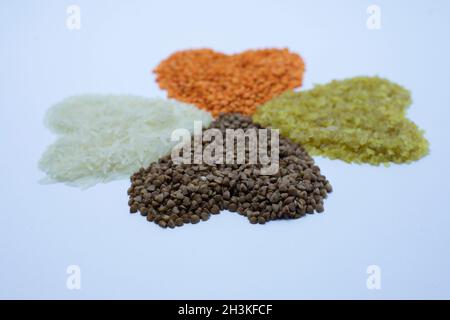 Verschiedene trockene Cerealien und Hülsenfrüchte in weißen und hölzernen Schalen, weißer Hintergrund. Veganes Protein-Konzept. Stockfoto