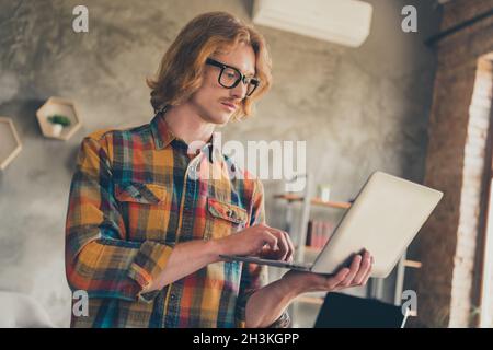 Foto Porträt Mann in Brille kariert Hemd arbeiten auf Laptop Surfen Internet-Codierung Stockfoto