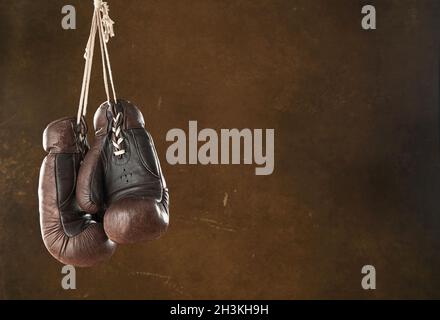 Alte Boxhandschuhe, die an einer Wand hängen Stockfoto