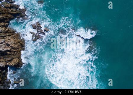 Luftaufnahme der wunderschönen Wellen des Ozeans und der felsigen Küste Stockfoto