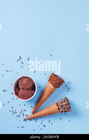 Eiszapfen und Schokoladenbecher auf blauem Hintergrund Stockfoto
