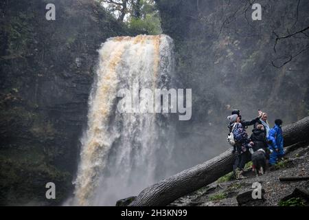 Ein Familienstopp für ein Selfie an den Henryd Falls in den Brecon Beacons, Wales, da starker Regen in der Gegend das Flusssystem füllt, um Besuchern perfekte Bedingungen zu bieten, um den Wasserfall in vollem Fluss zu sehen. Stockfoto