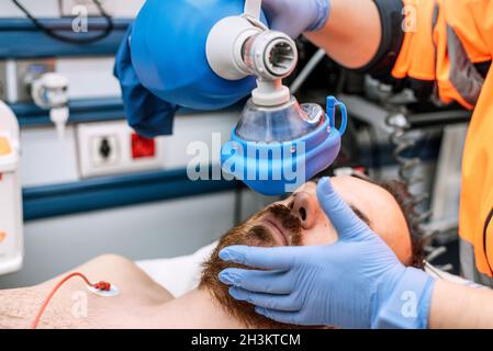 Die Krankenschwester hält einen Beatmungsbeutel in der Hand und verwendet einen Ambu-Beutel für die Beatmung des Patienten. Kardiopulmonaler Notfallreanimationsprozess Stockfoto