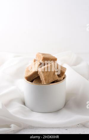 Karamellisierter Toffee aus Milch, Süßigkeiten in einer Schüssel, weißer Hintergrund Stockfoto