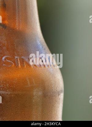 BILLERICAY, VEREINIGTES KÖNIGREICH - 14. Aug 2021: Eine Makroaufnahme eines Teils einer eiskalten Flasche Singha, dem original thailändischen Bier Stockfoto