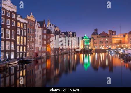 Amsterdam, Niederlande im Damrak bei Nacht. Stockfoto