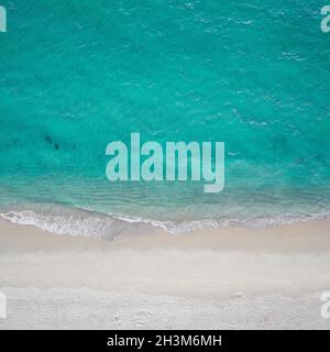 Luftaufnahme der Meereswellen, die gegen den leeren Sandstrand krachen Stockfoto