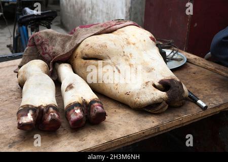 Kopf und Fuß einer geschlachteten Kuh auf einem informellen Markt in der alten chinesischen Stadt Songpan, die von einer Mauer umgeben ist. Nord-Sichuan, China. (125) Stockfoto