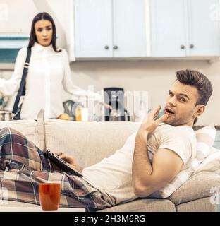 Mann im Pyjama gähnt beim Liegen auf der Couch Stockfoto