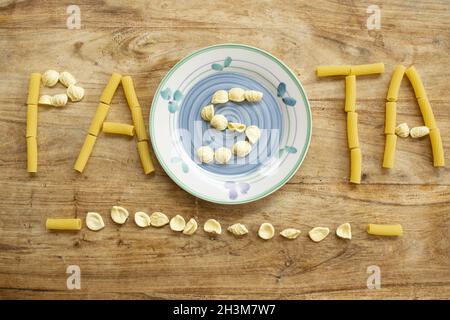 Pasta-Wort mit Nudelkörnern auf Holzhintergrund geschrieben Stockfoto