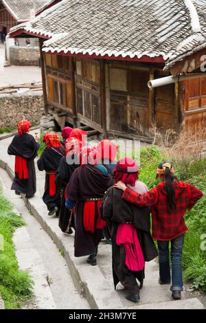 Eine Gruppe buddhistischer Gläubiger geht einen Fußweg/Pfad von einem kleinen Tempel über der Stadt; tibetische Frauen/ethnische Frauen Tibets, wohnhaft oder ortsansässig in die von Mauern umgebene chinesische Stadt Songpan im Norden von Sichuan, China. Im Buddhismus kann eine Frau Nonne sein. (125) Stockfoto