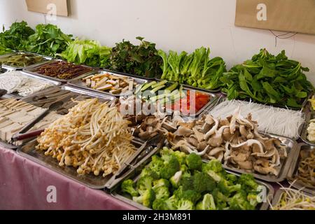 Tabletts mit frisch zubereitetem Salat und Gemüse aus frischem Anbau zum Verkauf in einem Lebensmittelgeschäft in der alten chinesischen Stadt Songpan (alte Stadtmauer) im Norden von Sichuan, China. (125) Stockfoto